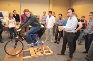 Students demonstrate a bicycle modified to generate electricity. The device will be used for K-12 classroom outreach.