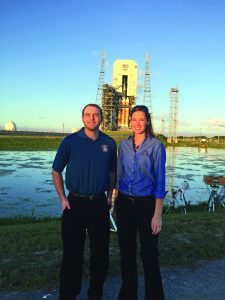 Casey O'Hayre and Heather McKay in front of the Delta IV Heavy and Orion EFT-1 spacecraft the day before launch at Kennedy Space Center.