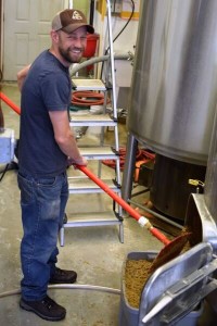 Josh Robbins '95, PhD '03 rakes out the grain from the mash tun at Mountain Toad Brewing. 