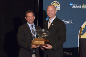 David Hansburg stands next to Chris Graham, holding the 2016 RMAC All-Sports Cup.