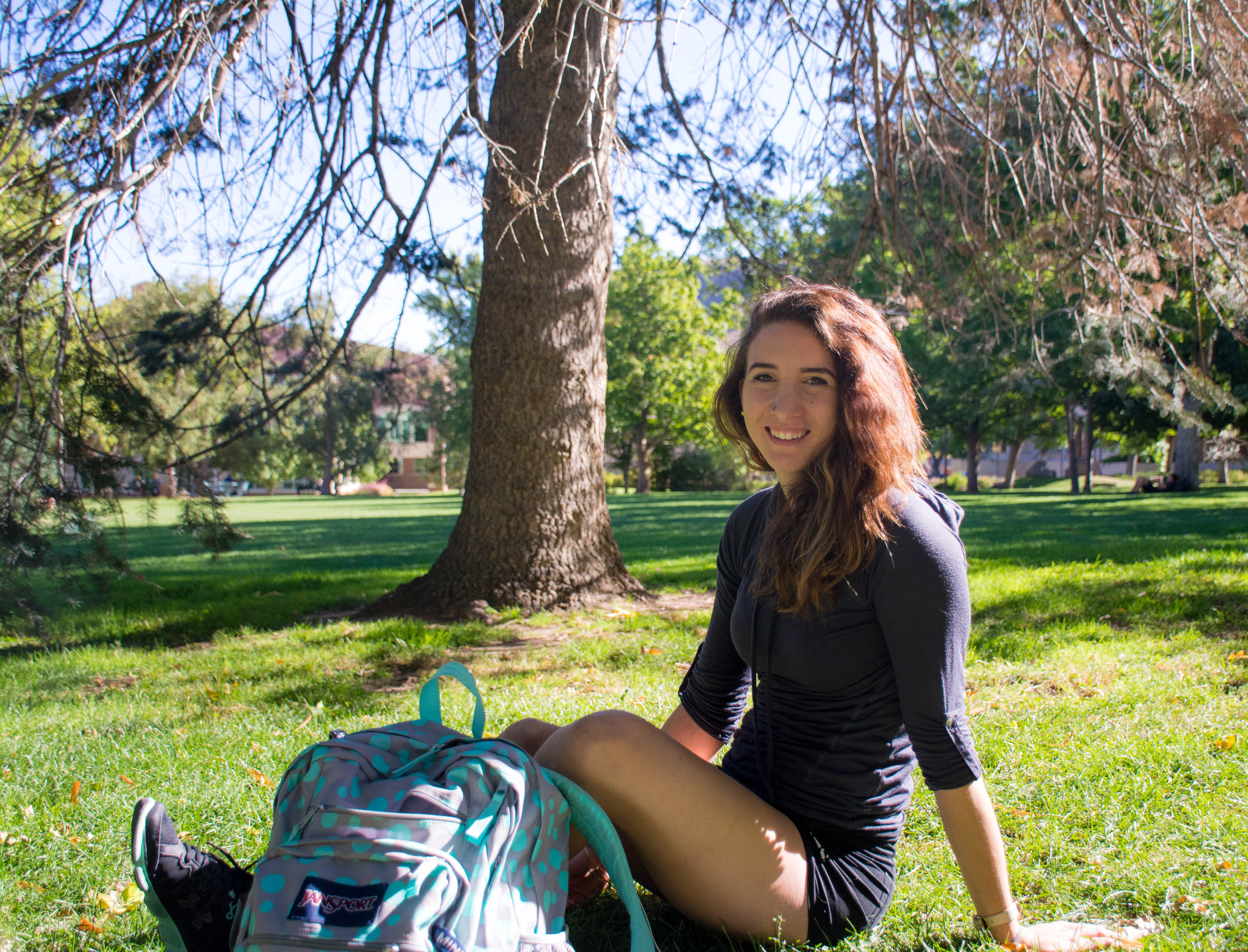 Paige Bowling sitting on the grass on the Mines campus