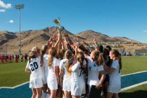 Mines' Women's Soccer team holds up their championship trophy