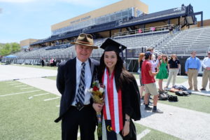 Terry Laverty stands with a female student on the football field during commencement