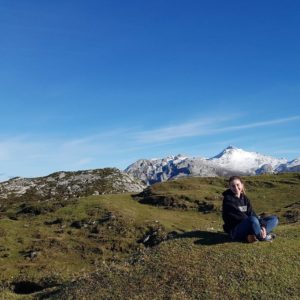 Megan Graf sits cross legged in a national park