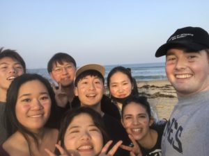 Sam Fiorica takes a selfie with several friends on a beach