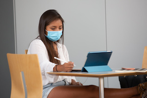 Student studying with mask and ipad