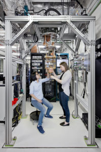 IBM Quantum Computing Scientists Hanhee Paik (left) and Sarah Sheldon (right) examine the hardware inside an open dilution fridge at the IBM Quantum Lab at IBM's T. J. Watson Research Center in Yorktown, NY. Photo by Connie Zhou for IBM