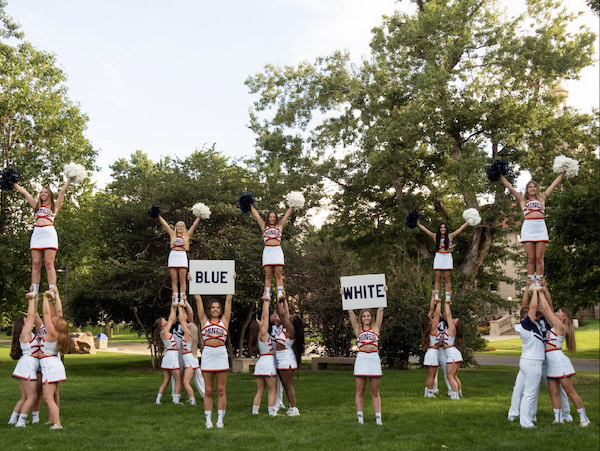Mines cheer team holding up signs that say "Blue" and "White"