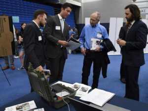 Four Mines students explain a project to an alum.