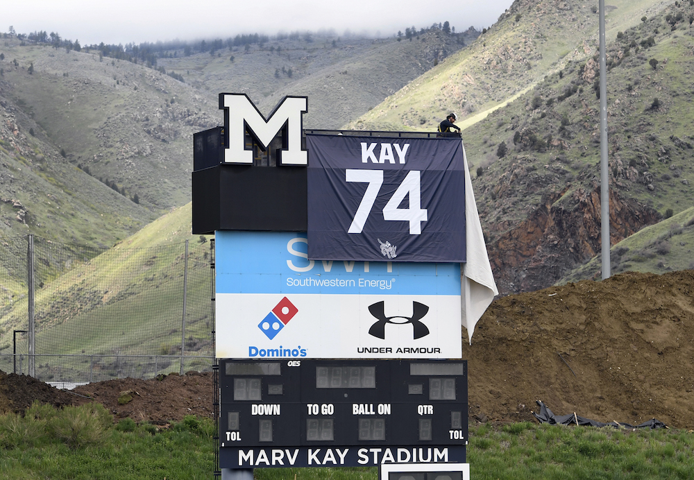 Mines football scoreboard with Marv Kay memorial jersey hanging at the top