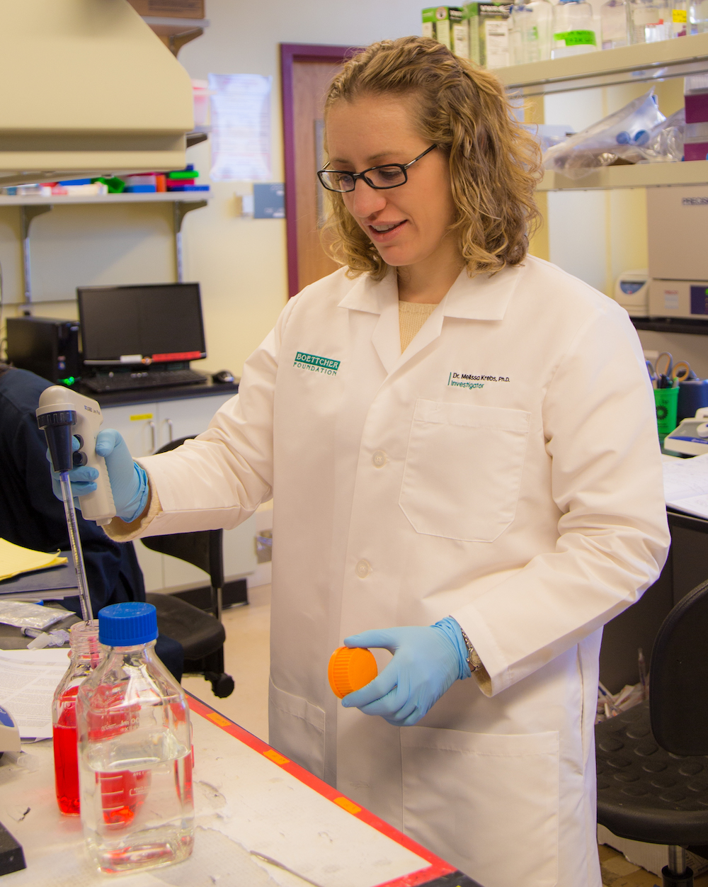 Melissa Krebs holding a syringe in a lab